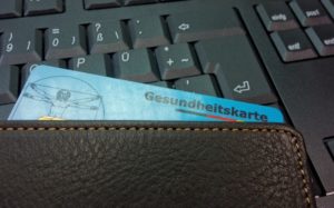 Krankenkassen Karte in Geldbeutel auf Tastatur