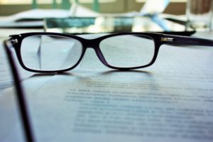 Brille auf Unterlagen für Schuldnerberatung