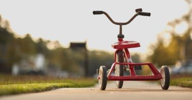 Rotes Dreirad eines mit Kindergeld geförderten Kindes