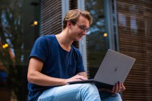 Student informiert sich an Laptop über Kredit mit Bürgen
