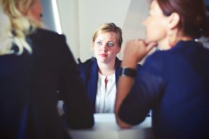 Zwei Frauen beraten Dritte Frau bei Schuldnerberatung