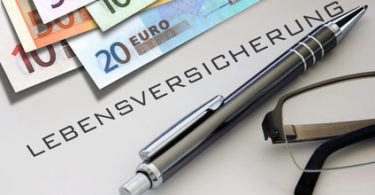 Lebensversicherung Geld Stift und Brille auf Tisch