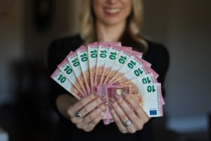 Frau hält Zehn Euro Scheine von Kredit ohne Schufa