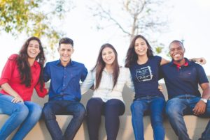 Fünf Studenten mit Studienkredit Arm in Arm